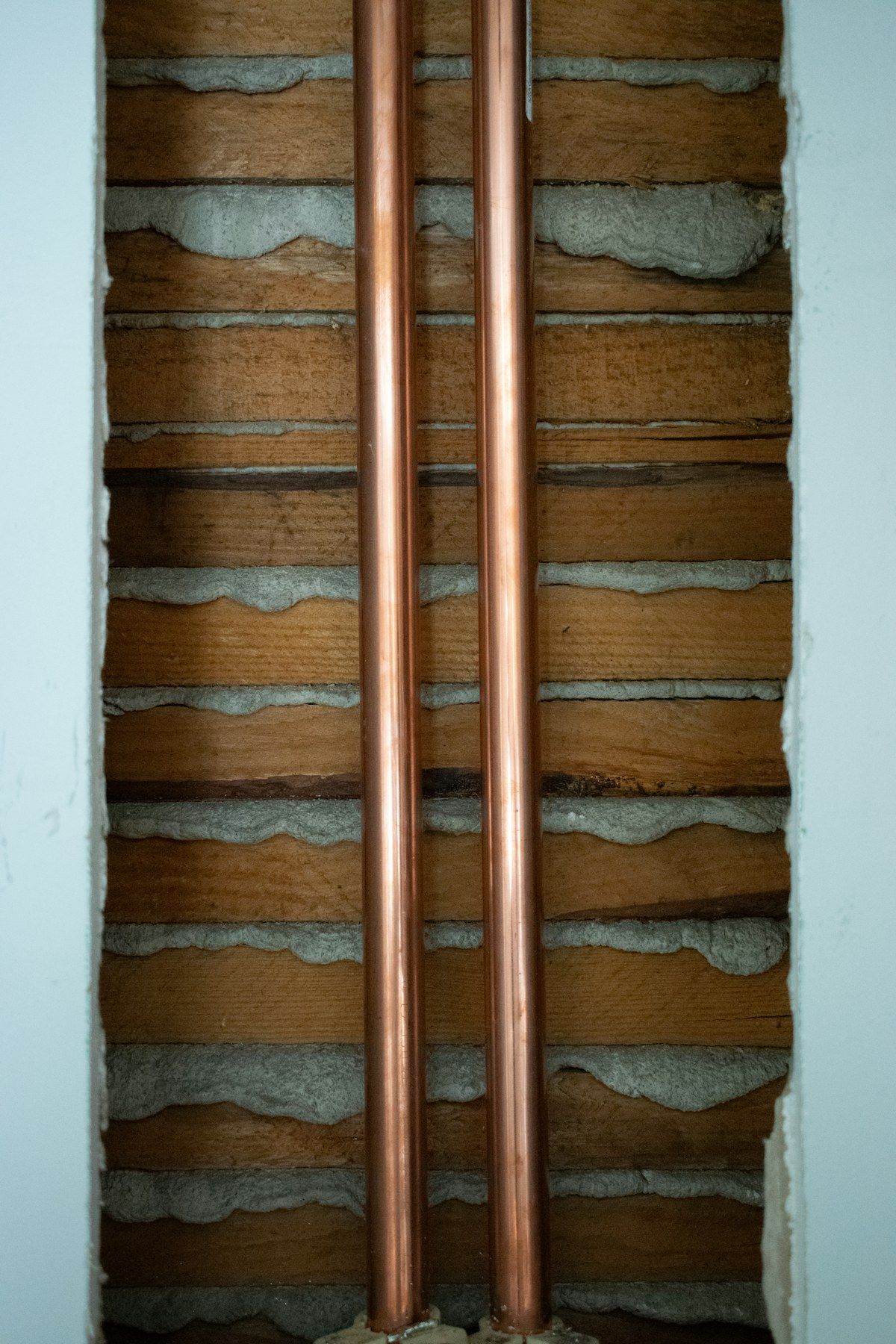 Copper water pipes running up an interior wall