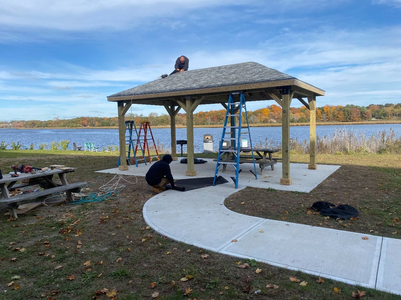 Forty’s crew finishing a timber-frame pavilion beside the water